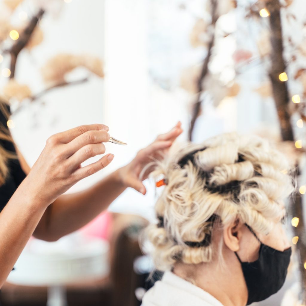 Hairdresser doing a perm for a customer