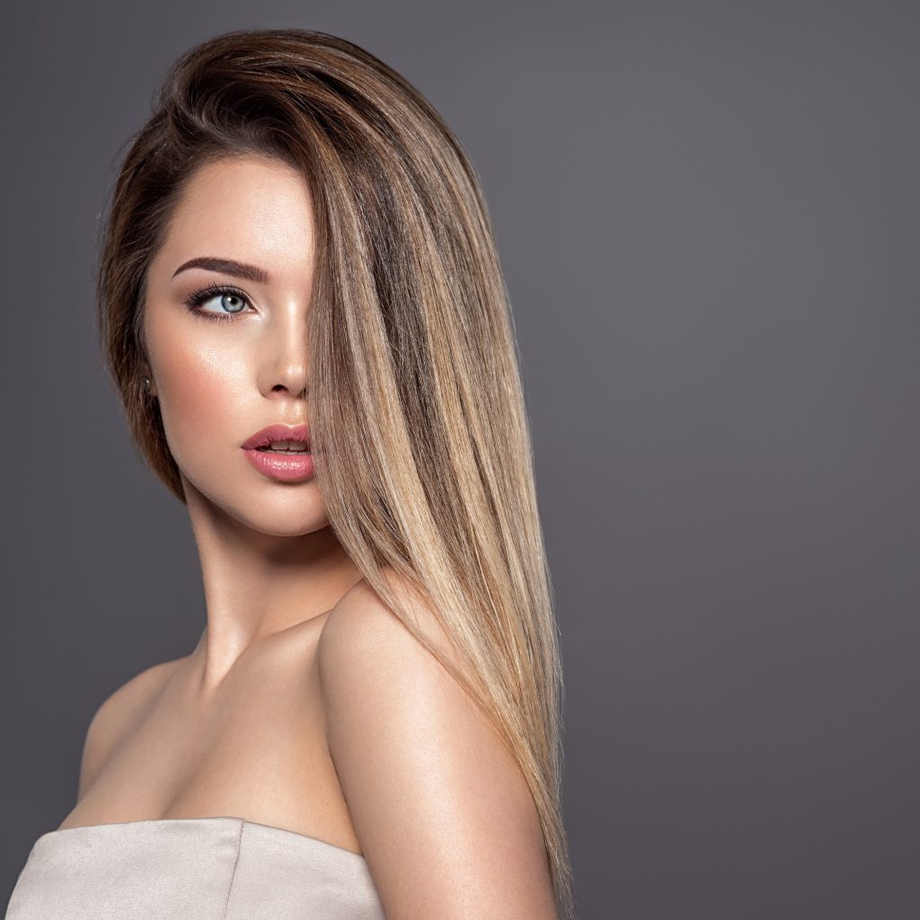 Young woman with long straight hair. Blond girl.